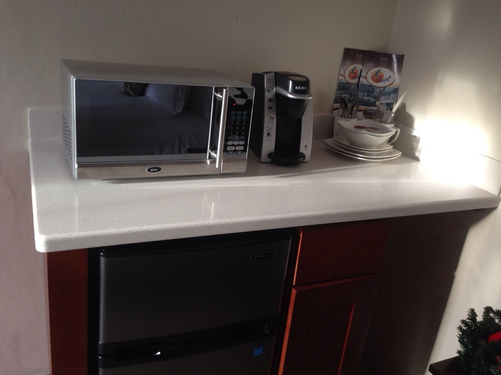Une petite cuisine équipée d’un four à micro-ondes, d’une machine à café et d’un petit réfrigérateur.