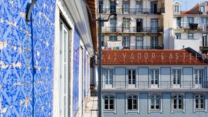 Un edificio con paredes de paredes con un diseño azul y blanco, techo de tejas y varios balcones.