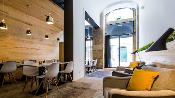 Un interior moderno con zona de comedor, asientos y un ventanal grande.