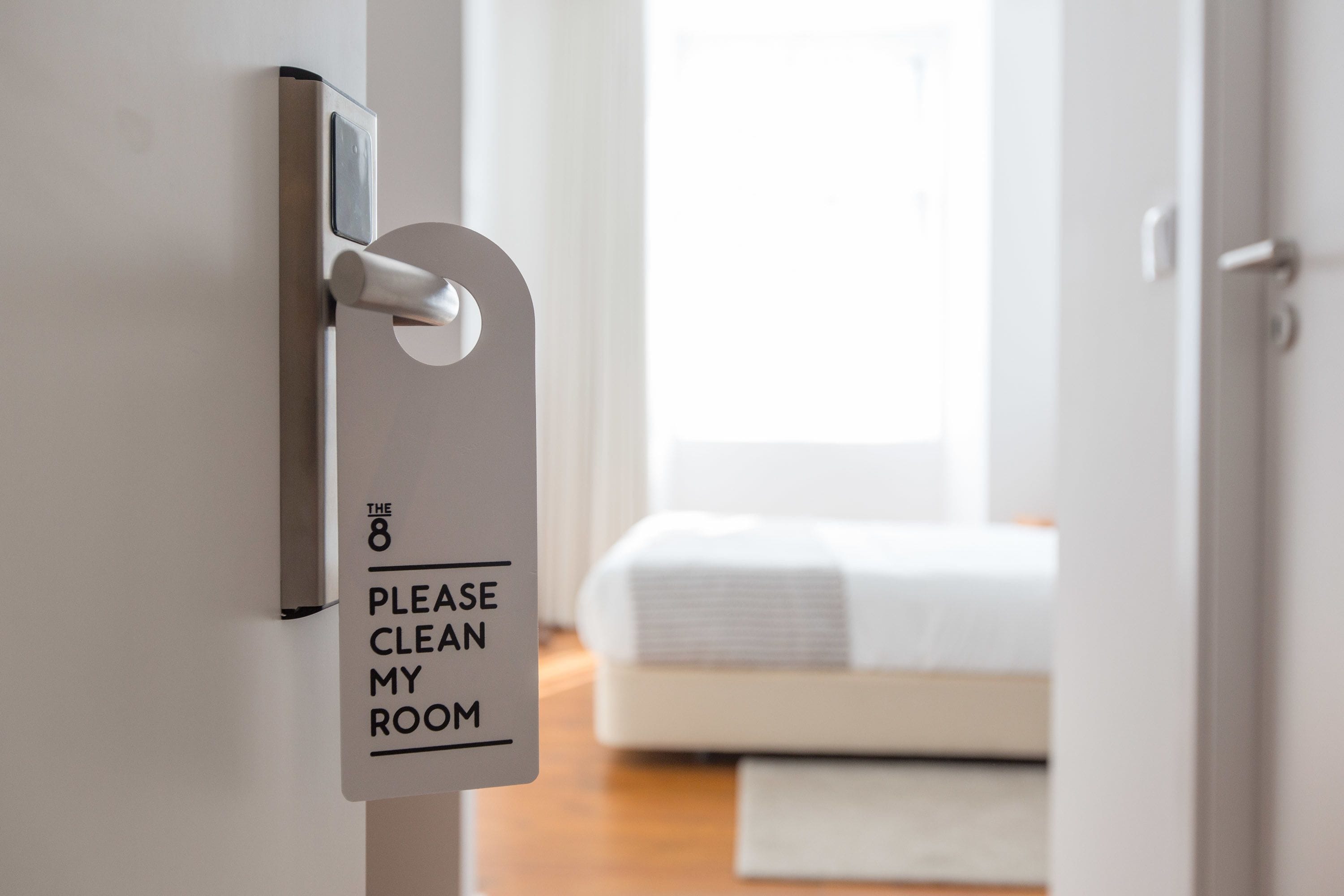 A door with a sign that reads "Please clean my room."