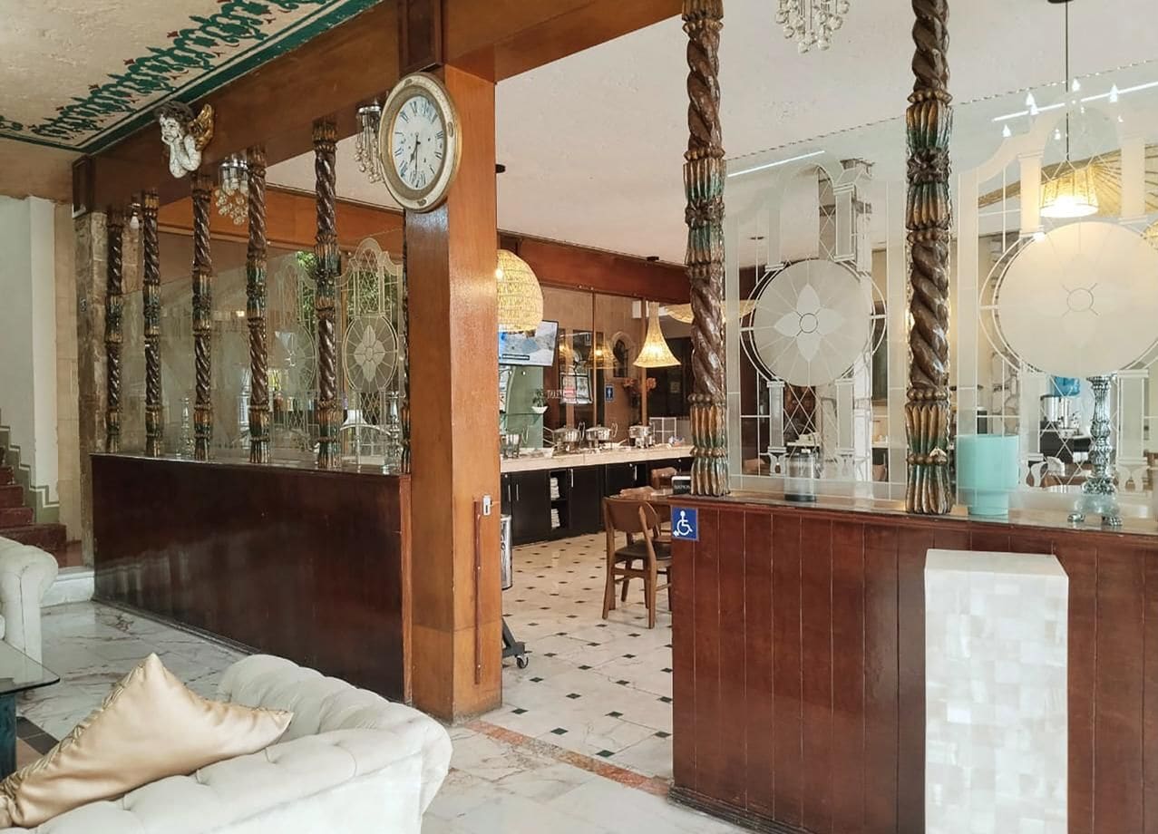 A hotel lobby with a bar area, seating, and a wheelchair-accessible sign.