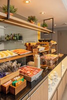 Una mesa de buffet con diversos alimentos y salsas.