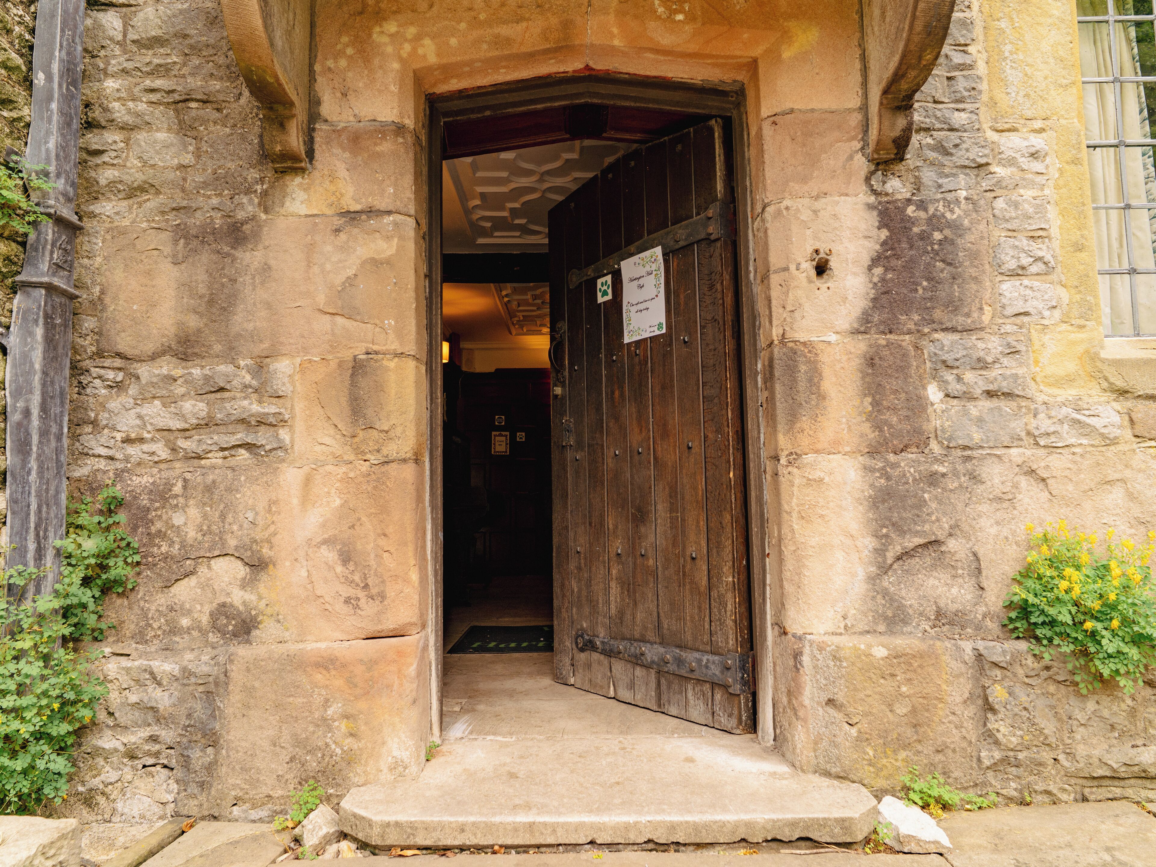 Un bâtiment en pierre avec une porte en bois et un petit marchepied menant à l’entrée.