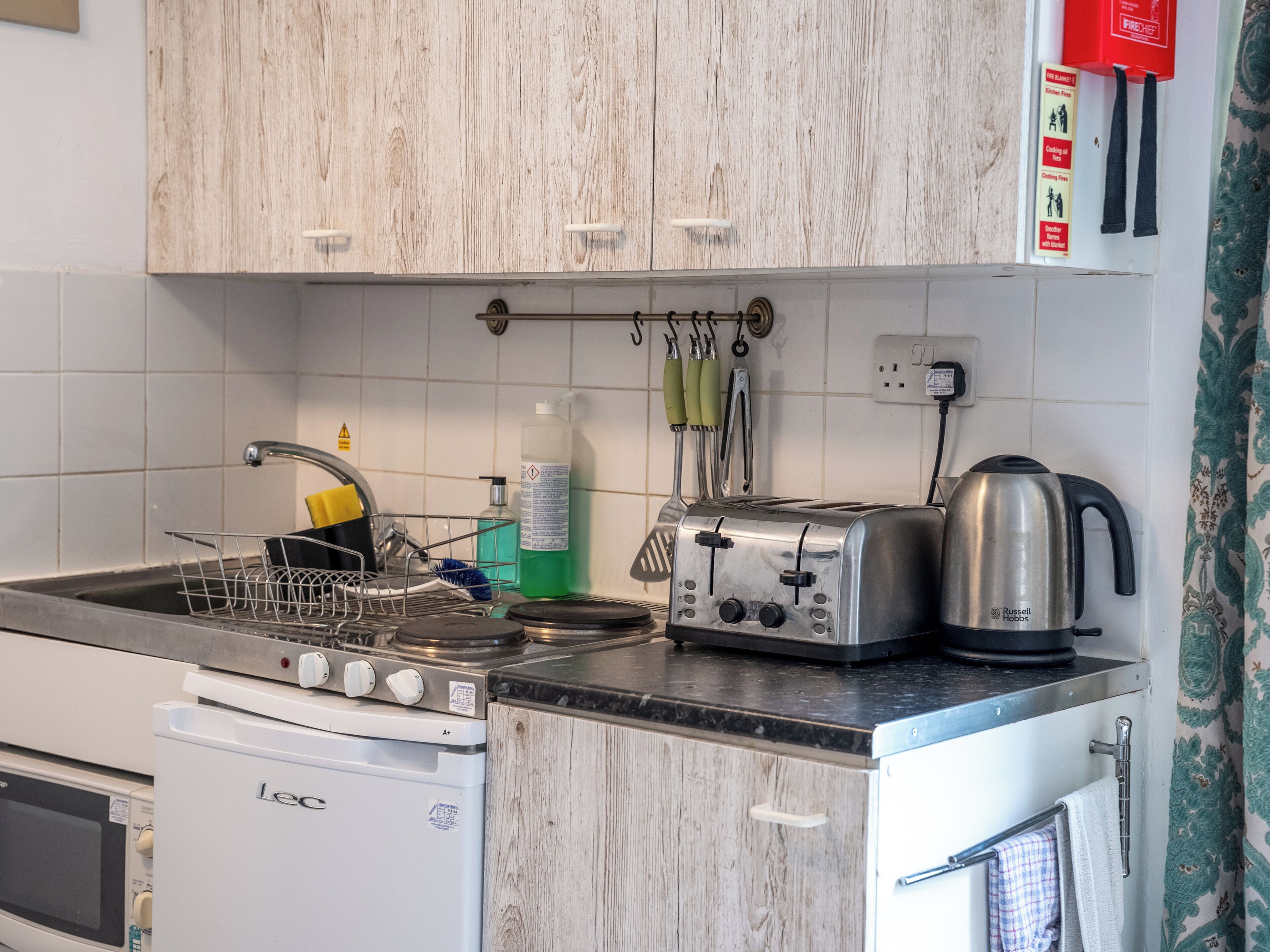 Una cocina con lavavajillas, estufa, tostadora y hervidor.
