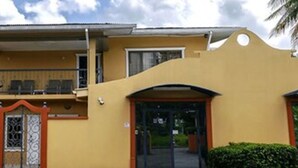 A two-story building with a balcony on the upper floor. - Palms Hotel Trinidad (Arouca)