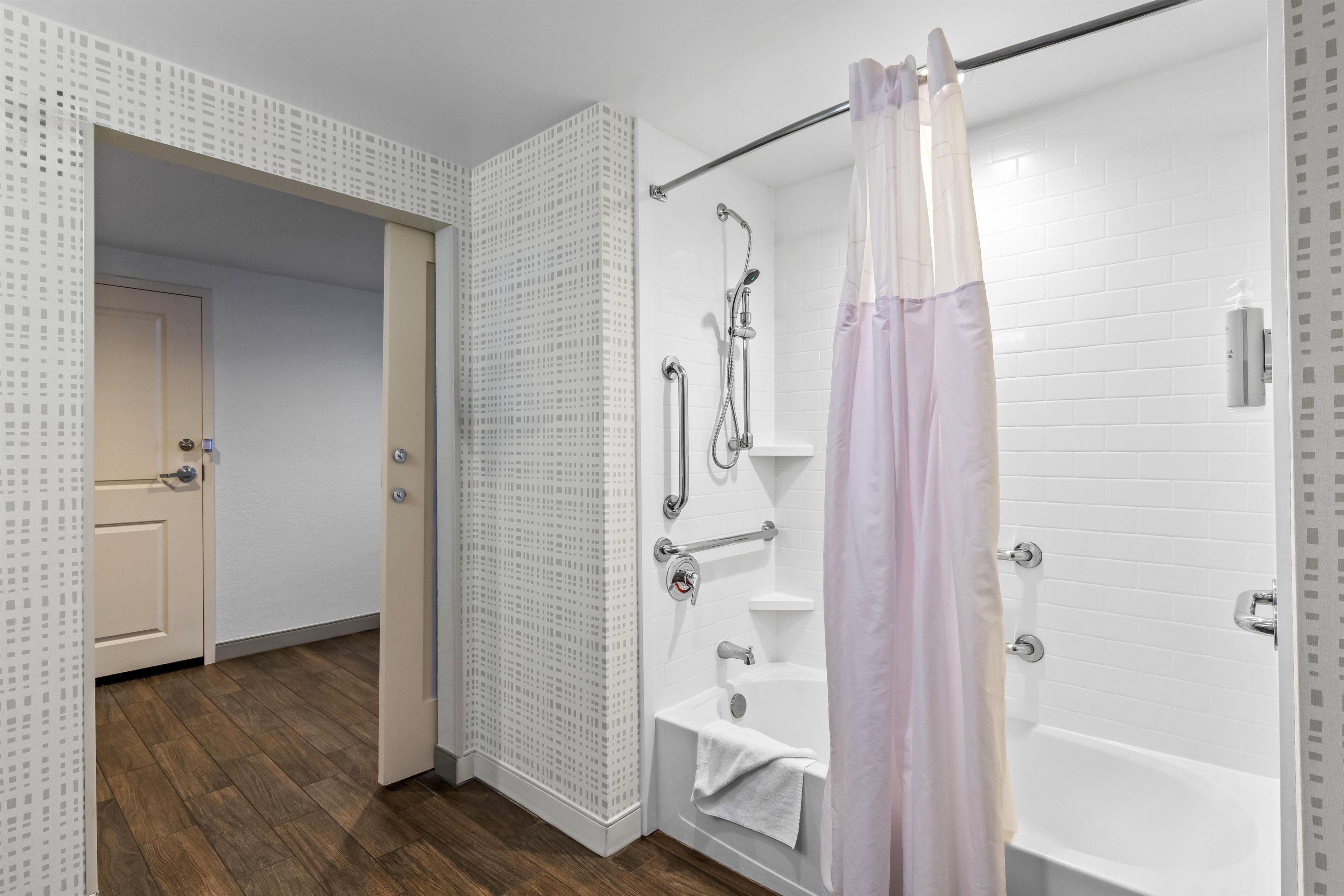 A modern bathroom with a shower, a bathtub, and a toilet.