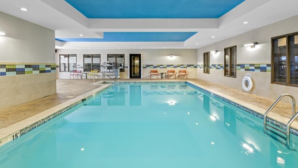 Une piscine intérieure à l’eau d’un bleu limpide, avec des murs carrelés et un plafond agrémenté d’une touche de bleu.