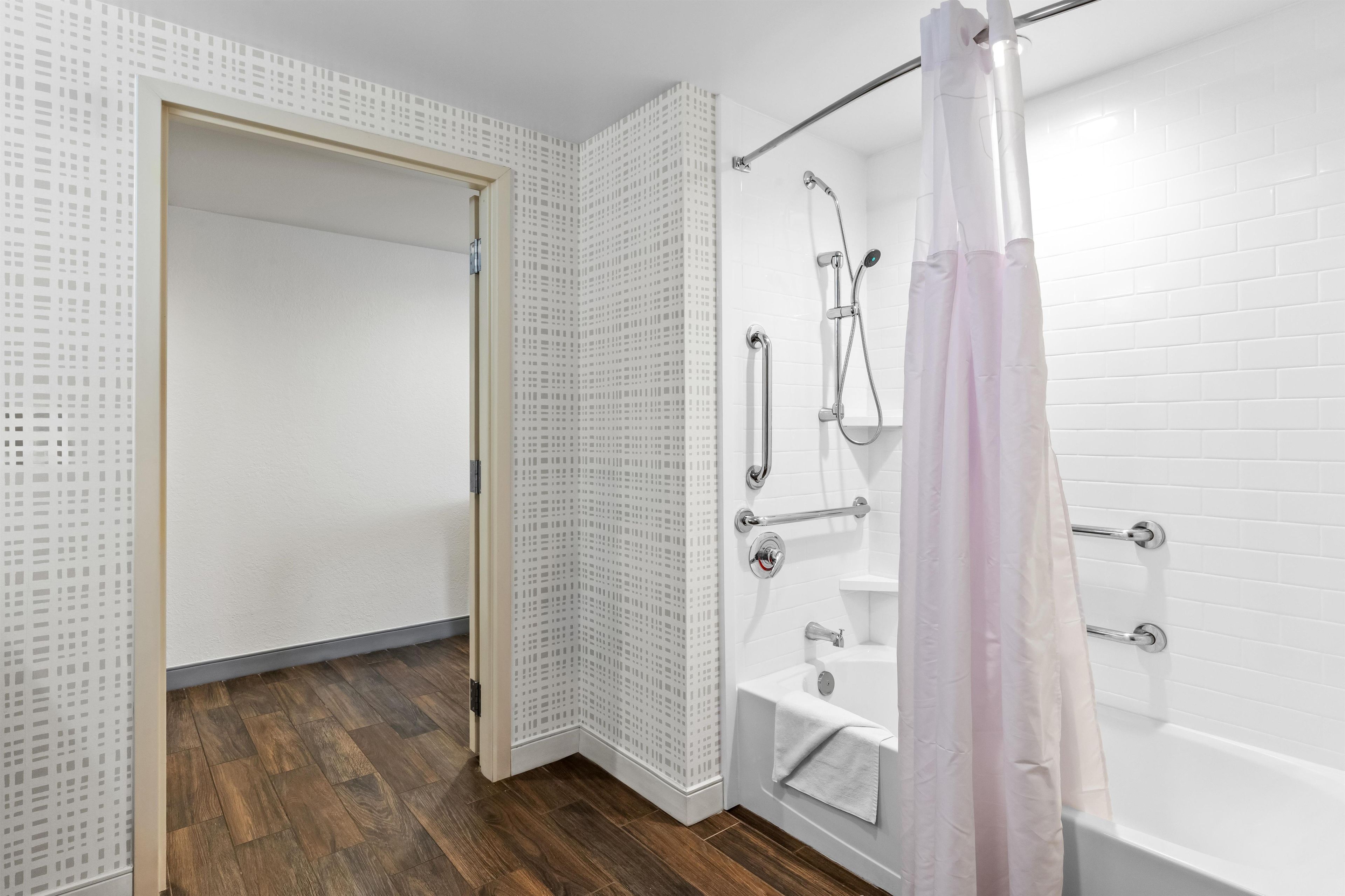 A modern bathroom with a shower, a toilet, and a sink.