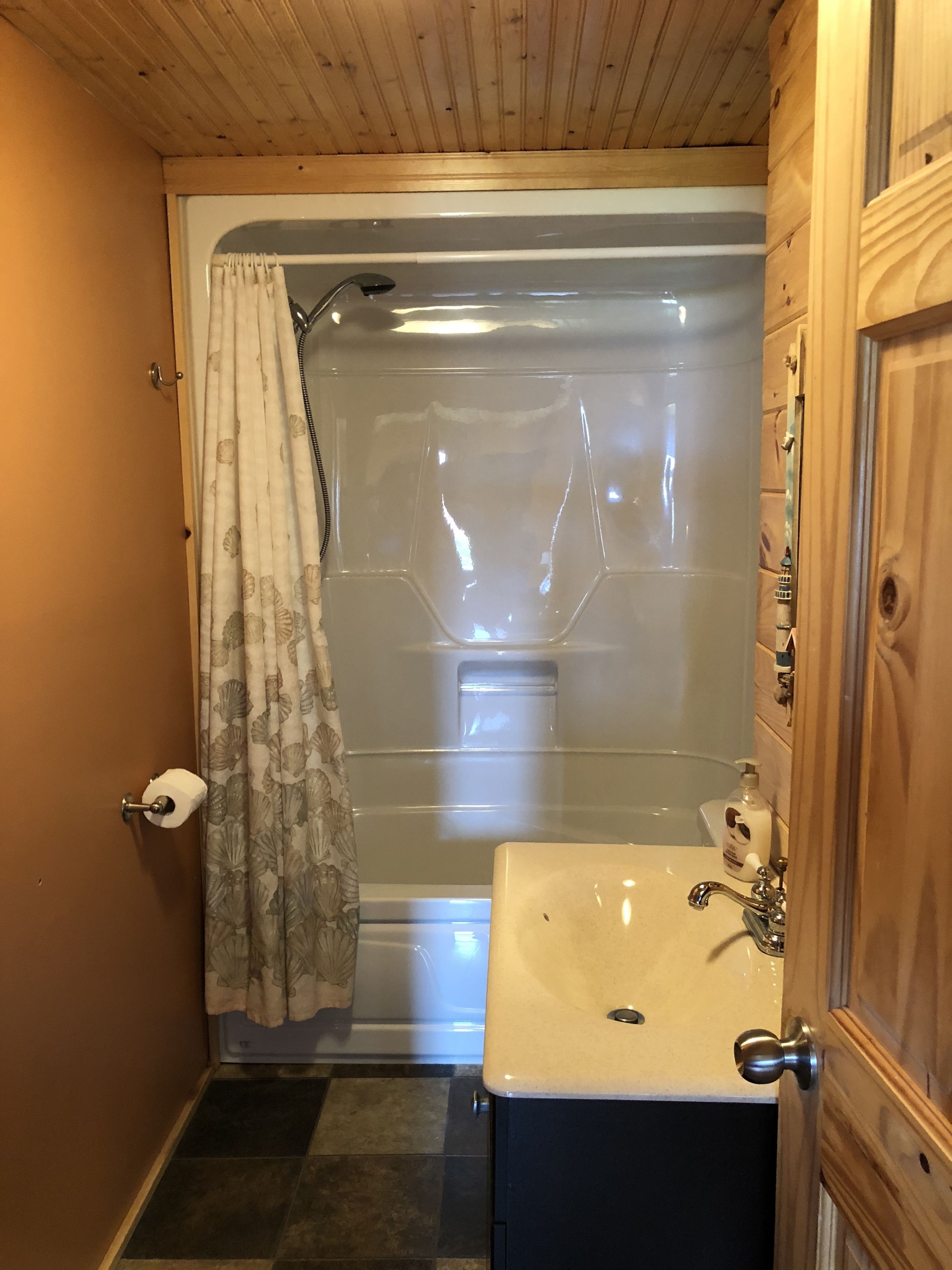 A bathroom with a shower, toilet, and sink.