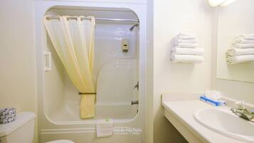 Un bagno con doccia, WC, lavandino e asciugamani.