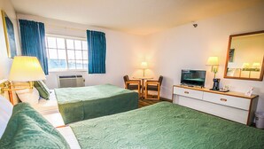 Une chambre d’hôtel avec deux lits, un bureau, une chaise, une télévision et une fenêtre avec des rideaux.