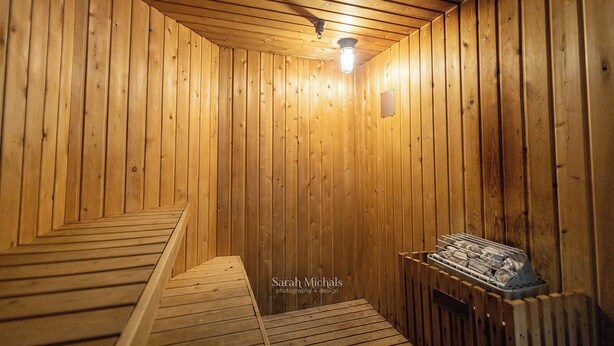 Un sauna en bois doté d’un plafond incliné et d’un seul luminaire.