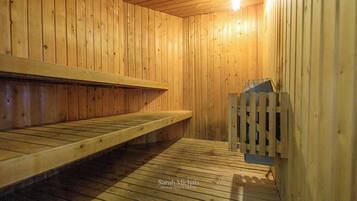 A sauna with wooden benches and a wooden heater.