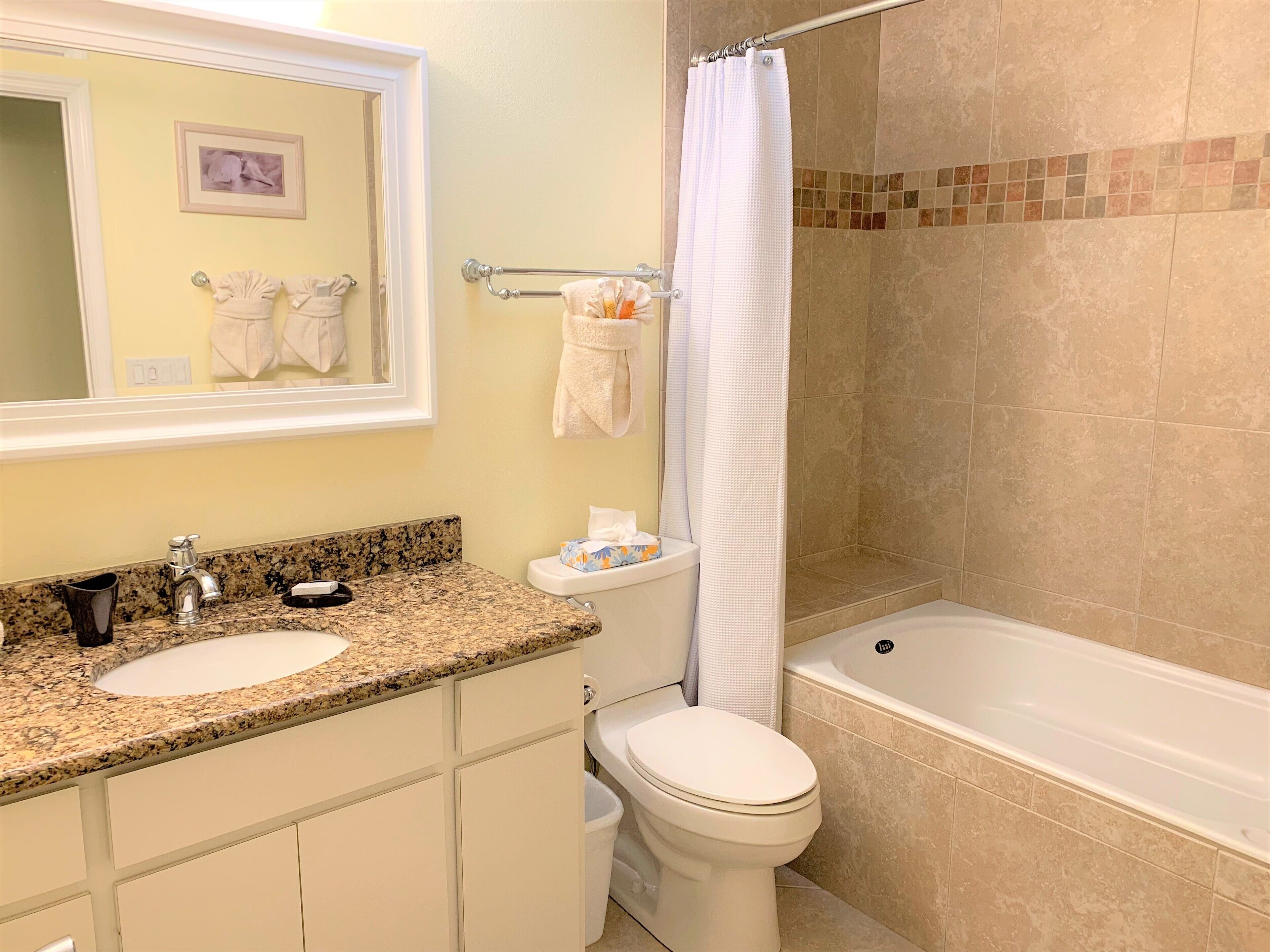 A bathroom with two sinks, a toilet, a bathtub, and a shower curtain.