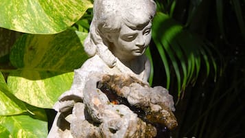 A stone statue of a figure holding a rock.
