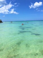 Perto da praia, areia branca, espreguiçadeiras, guarda-sóis 