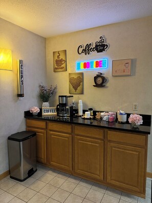 A kitchen with a coffee station, including a coffee maker, cups, and a sign that reads 'Coffee Time'. - Budget Host Inn & Suites (Escanaba)