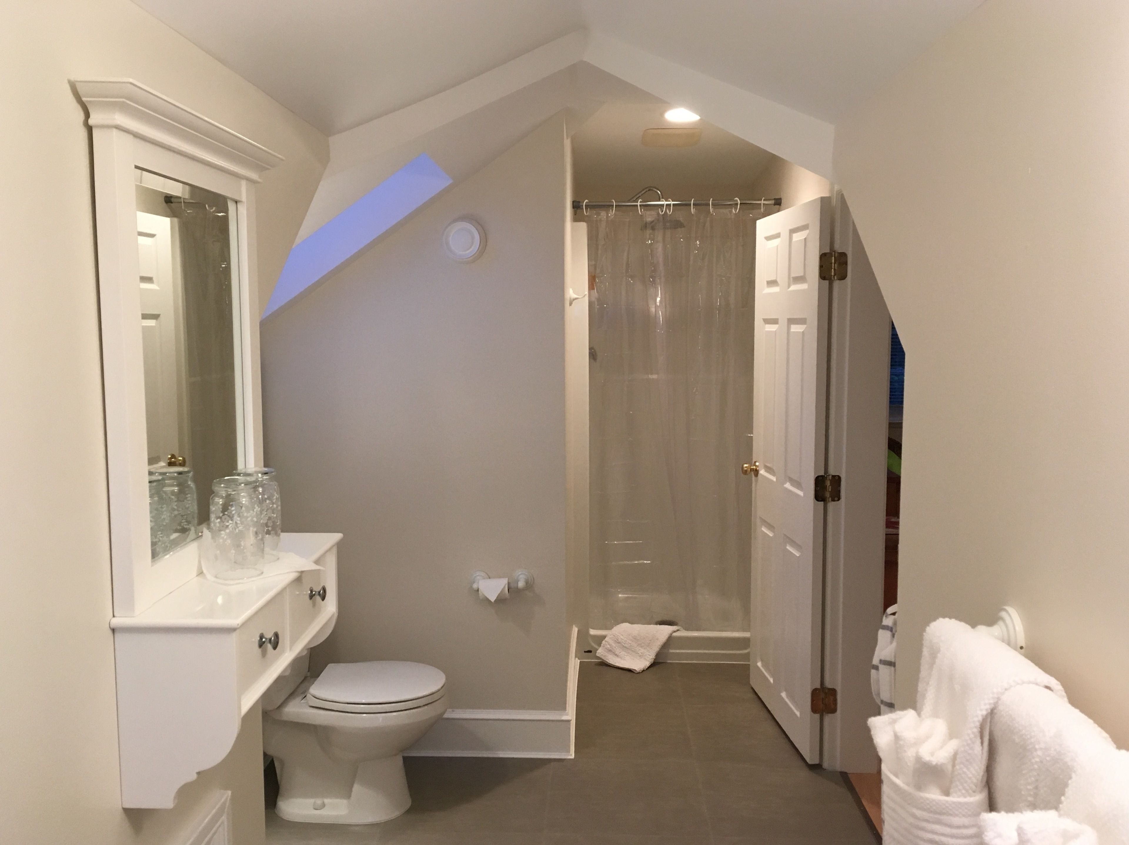 A bathroom with a toilet, sink, and shower.