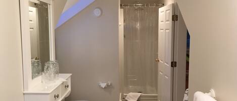 A bathroom with a toilet, sink, and shower.
