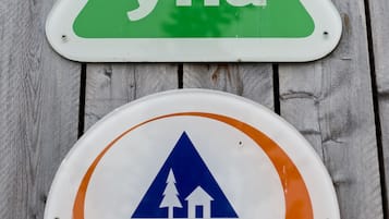 Dos carteles: uno verde con 'yha' y otro naranja con el logotipo de 'Hostelling International'.