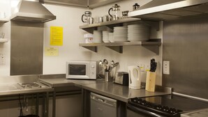 A modern kitchen with stainless steel appliances, including a microwave, toaster, and kettle, and a dishwasher. - YHA Boscastle - Hostel (Boscastle)