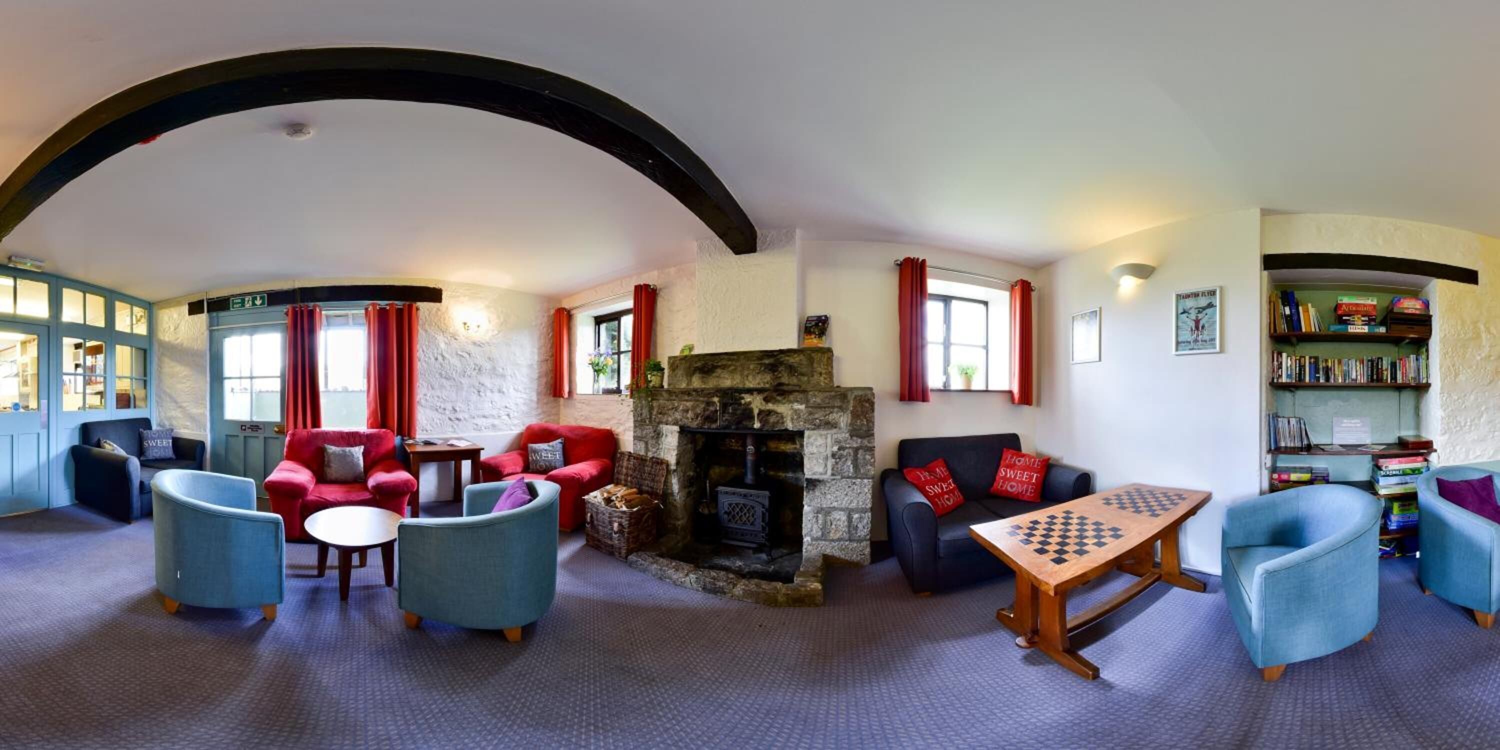 A cozy room with a fireplace, comfortable seating, and a chess table.