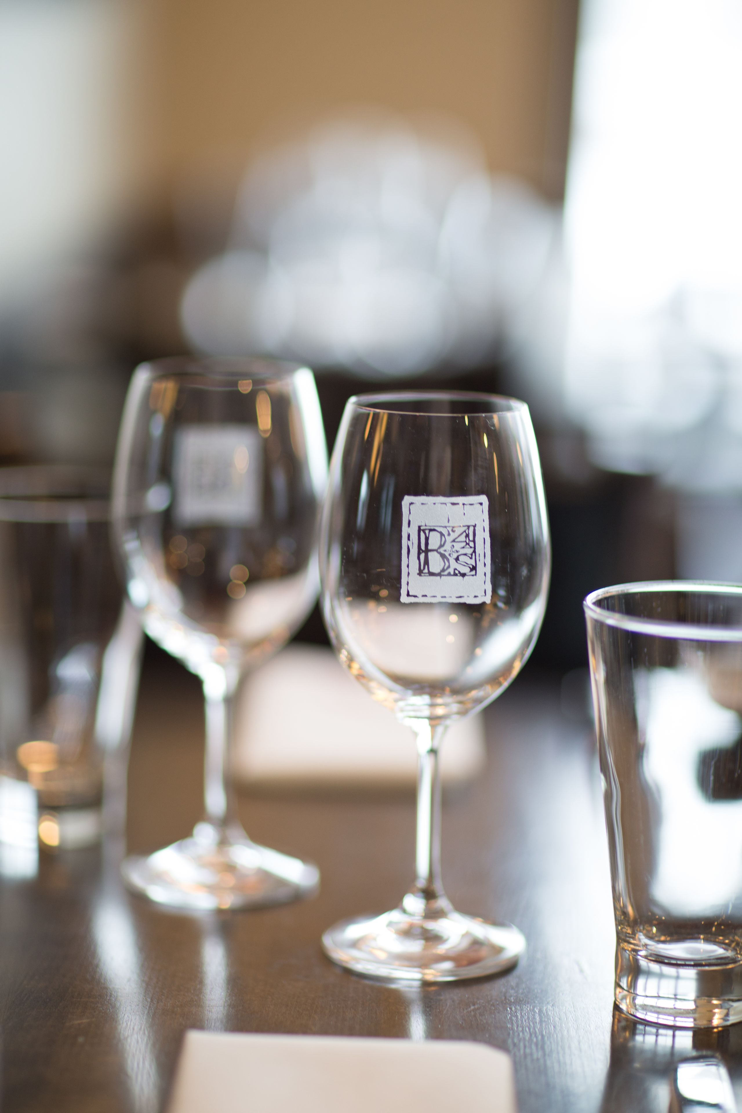 A row of empty wine glasses on a wooden table.