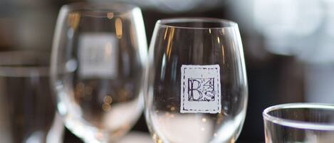 A row of empty wine glasses on a wooden table.