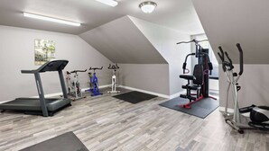 A gym with a treadmill, stationary bikes, and weight machines.
