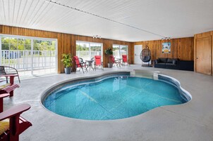 Uma área de piscina com piscina sinuosa, paredes de madeira e um ventilador de teto.
