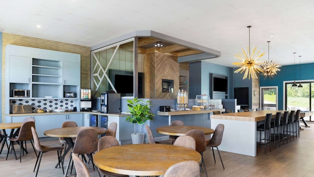 A modern kitchen with built-in appliances, a central island with seating, and a large window providing natural light.