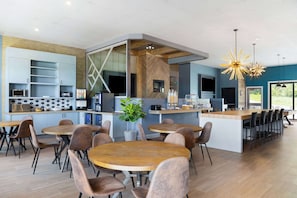 Una cocina moderna con electrodomésticos integrados, una isla central con asientos y un amplio ventanal que proporciona luz natural.
