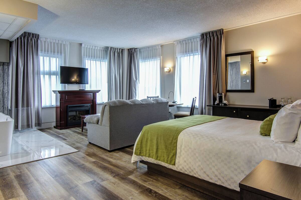 deluxe room, 1 queen bed | in-room safe, desk, iron/ironing board, cots/infant beds