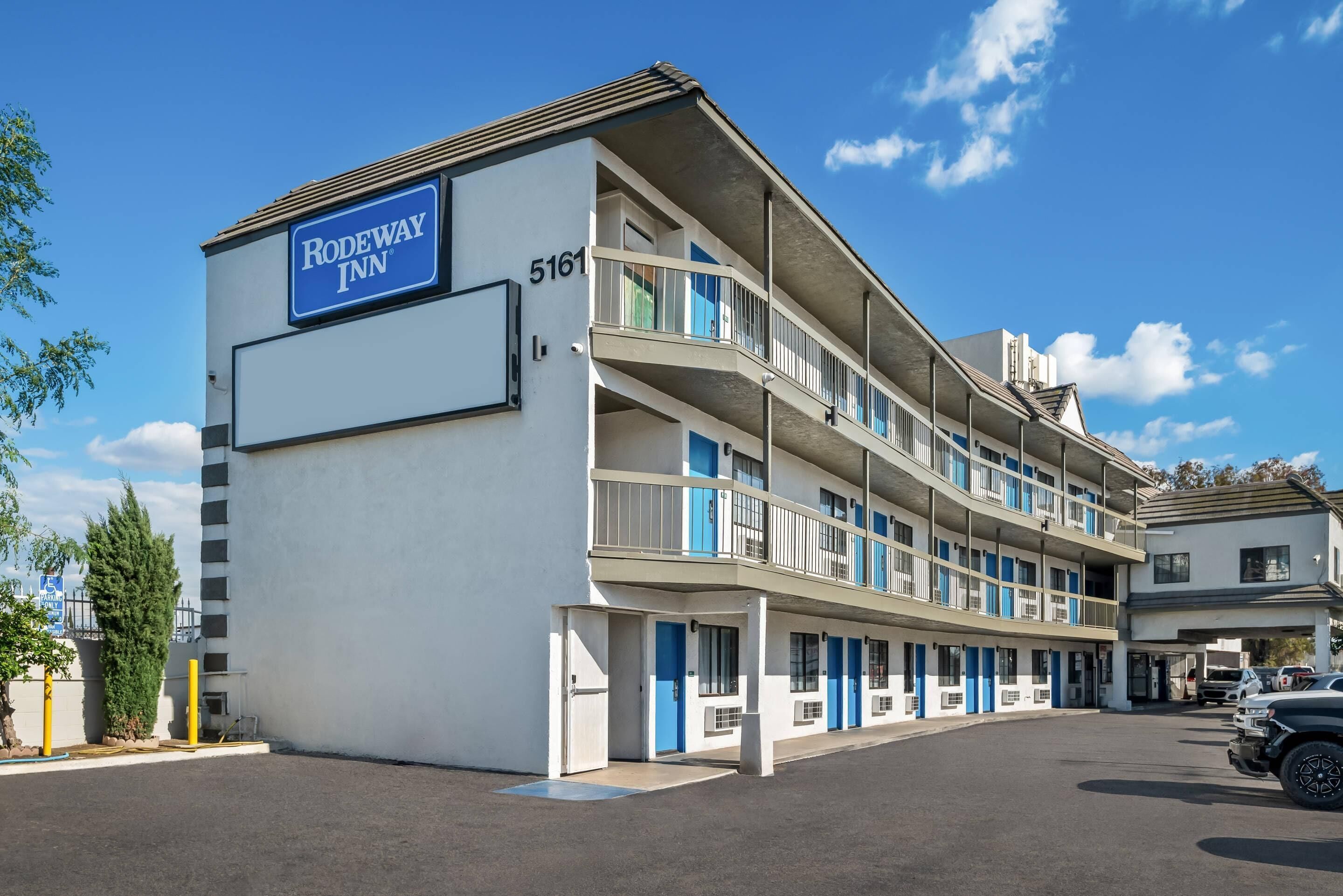 Un motel à plusieurs étages, avec une enseigne indiquant « Rodeway Inn » et le numéro 5161.