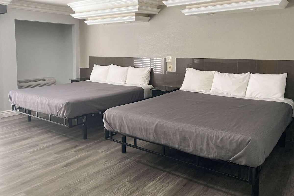 Ein Hotelzimmer mit zwei Einzelbetten, Holzboden und modernem Design.