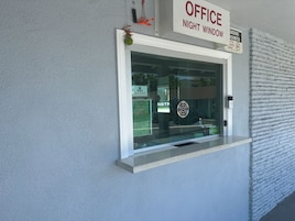 Una ventana con un cartel que indica 'OFFICE NIGHT WINDOW' y un cartel de 'PROHIBIDO FUMAR'.