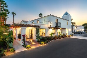A white building with a sign reading "Mason Beach Inn" and a balcony with a railing.
