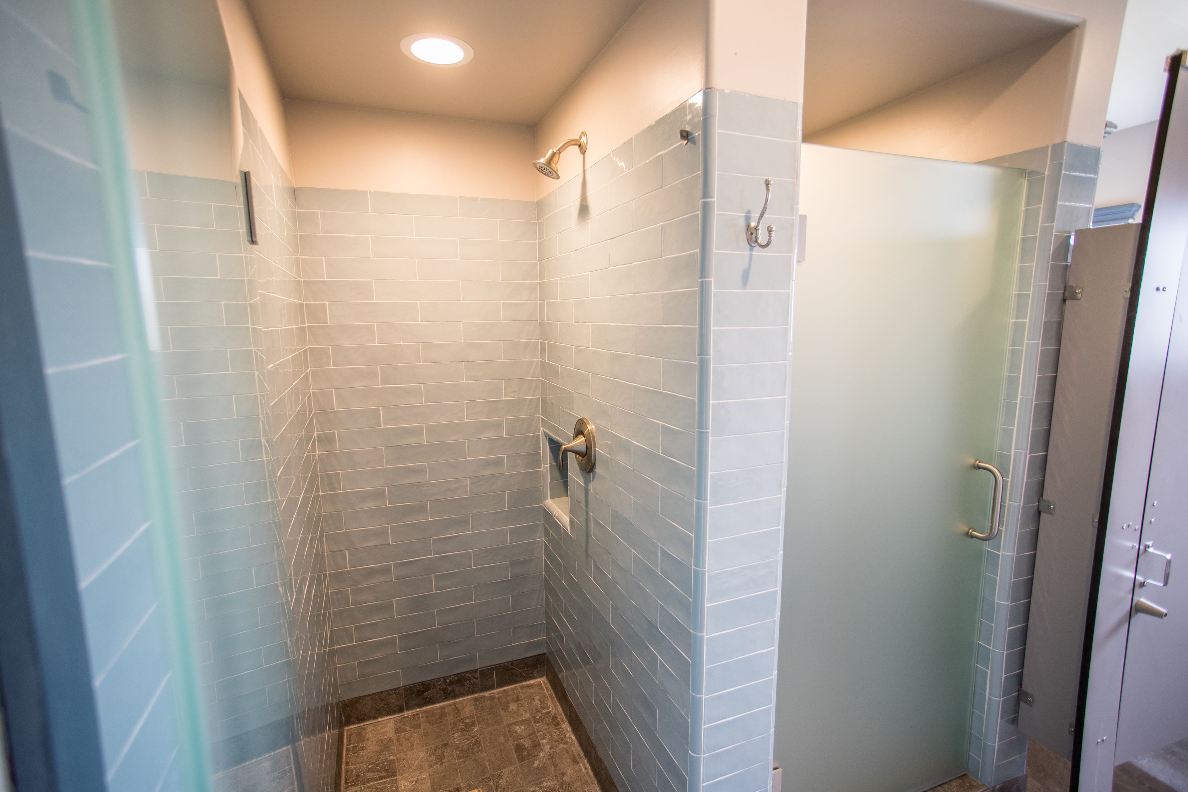 Ein modernes Badezimmer mit Dusche, gefliesten Wänden und einer Glastür.