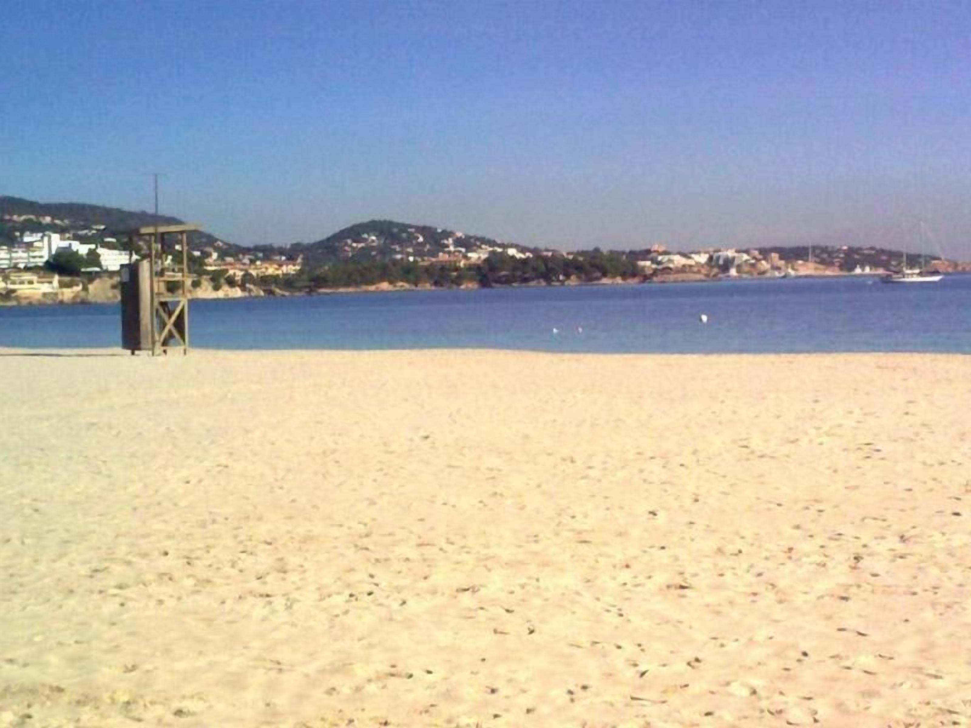 Una platja amb una torre de socorrisme i una vista clara de la costa.