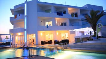 Een buitenzwembad, parasols voor strand/zwembad