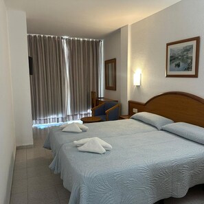 A hotel room with a large bed, a chair, a bedside table, a lamp, and a painting on the wall. - Marina Playa de Palma (Playa de Palma)