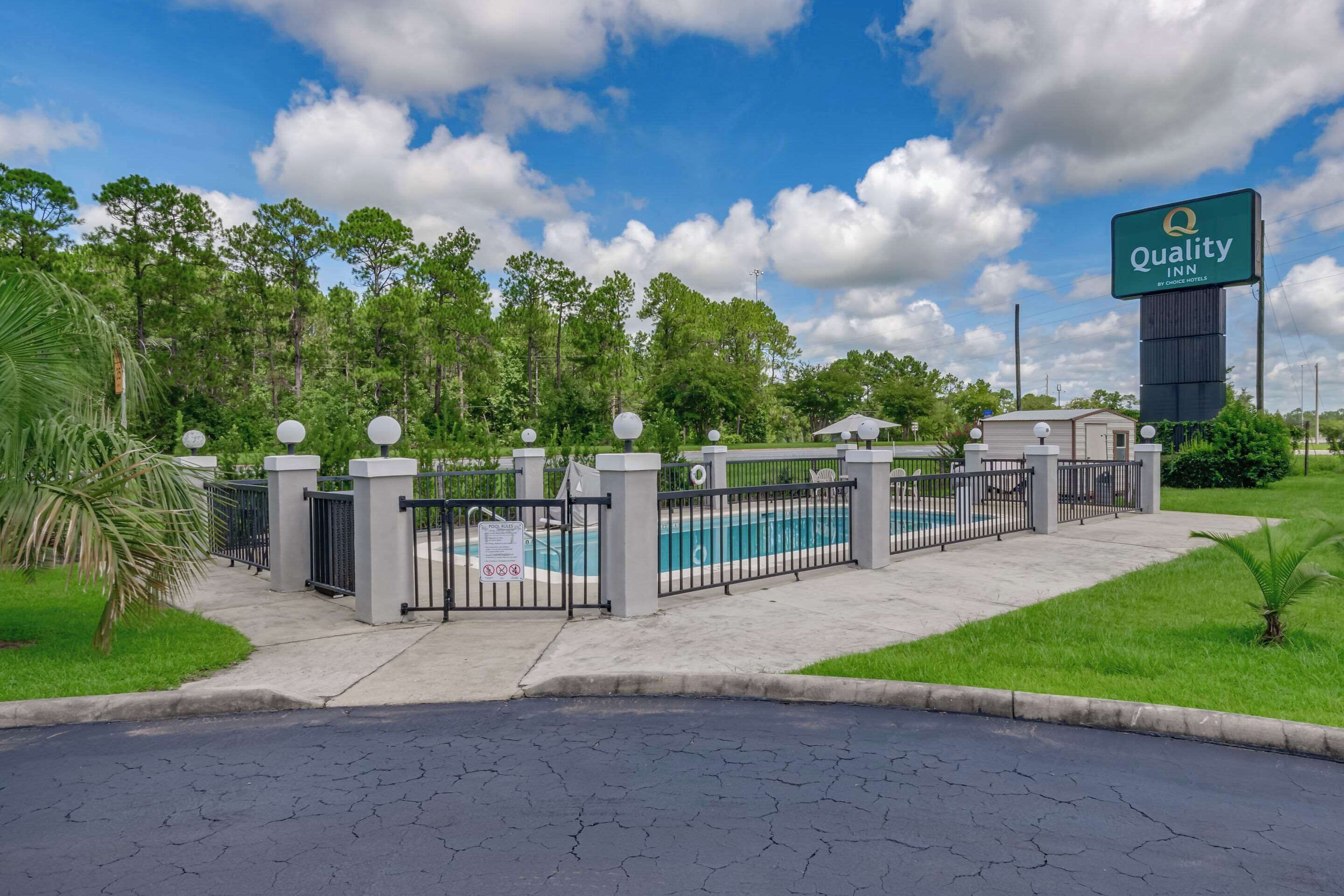 A gated pool area with a sign for Quality Inn by Choice Hotels.