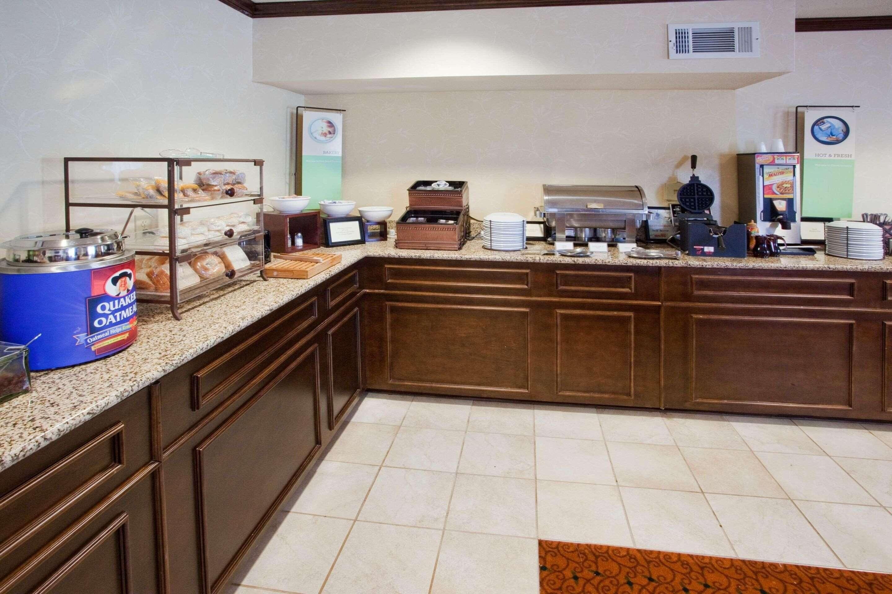 A breakfast bar with a coffee machine, a waffle maker, and a coffee dispenser.