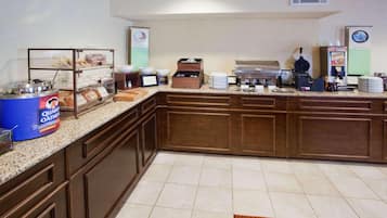 A breakfast bar with a coffee machine, a waffle maker, and a coffee dispenser.