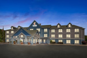Un hotel grande con un llamativo letrero Comfort Inn & Suites, varios accesos y un exterior bien cuidado.
