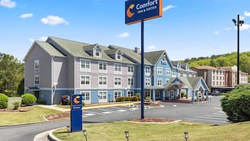 A Comfort Inn & Suites hotel with a large sign, a parking lot, and a well-maintained lawn.