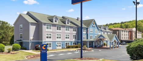 A Comfort Inn & Suites hotel with a large sign, a parking lot, and a well-maintained lawn.