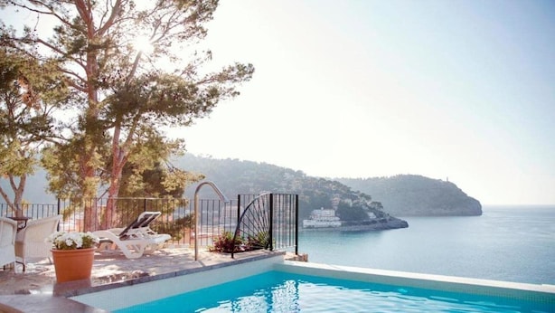 Une piscine avec vue sur la mer et un paysage montagneux.
