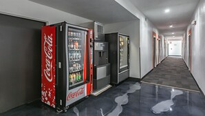En gang med automater, heriblandt en Coca-Cola køler og en vanddispenser.