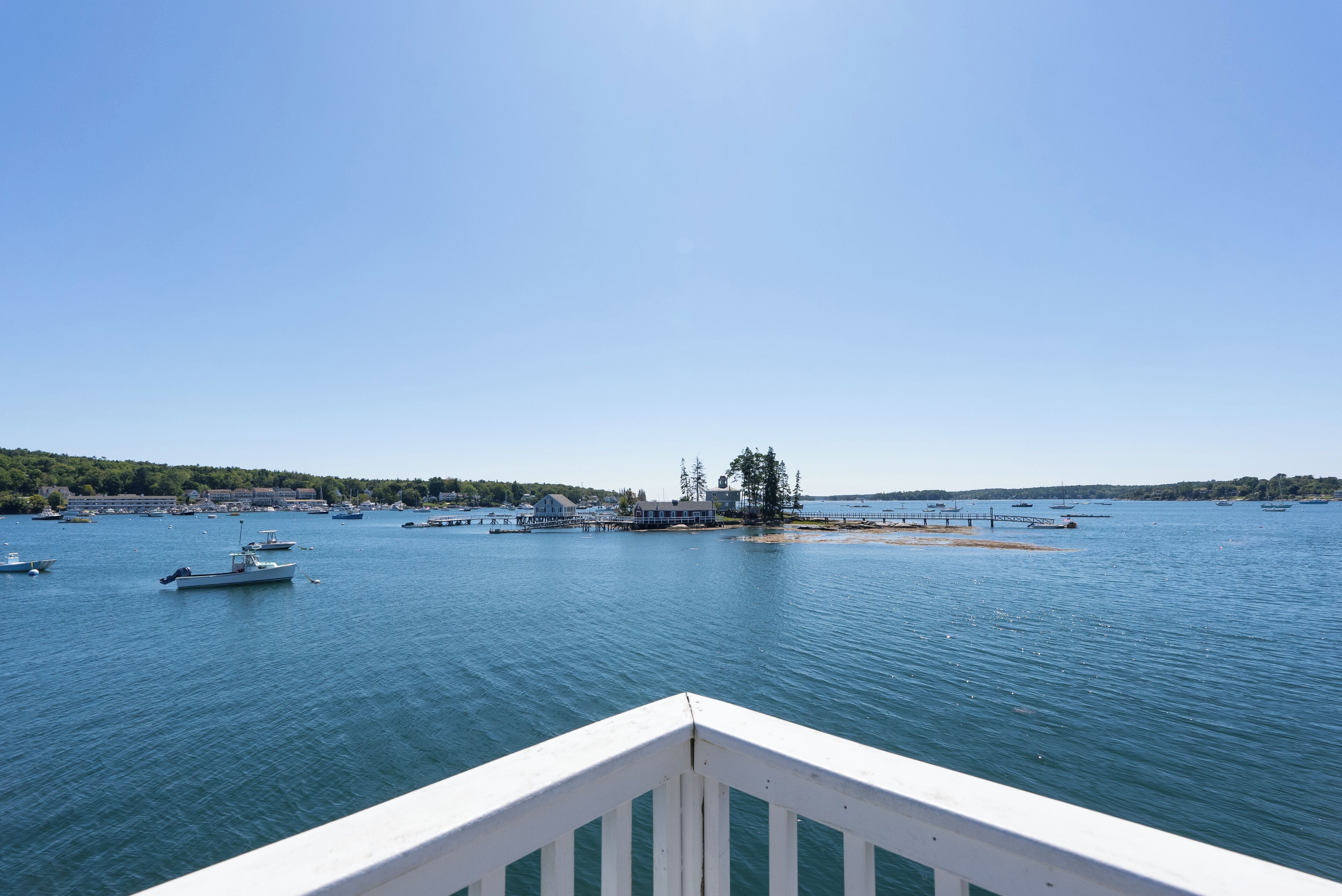 A marina with boats, a dock, and a small island with trees.